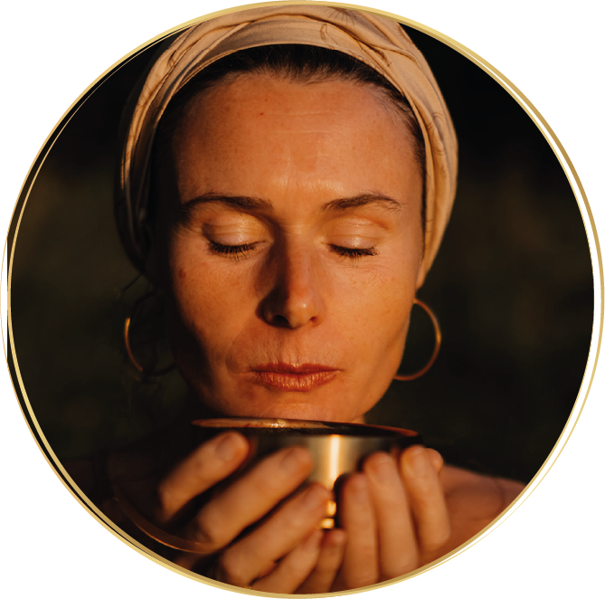 Ava mit Turban hält eine Schale Cacao vor ihrem Gesicht und genießt achtsam den Moment mit geschlossenen Augen.